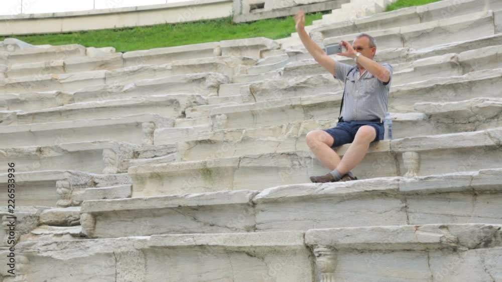 Male tourist filming in antique stadium Male tourist filming in antique stadium