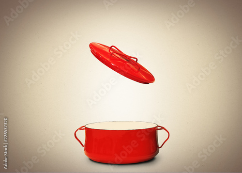 Big red pot for soup on the brown background