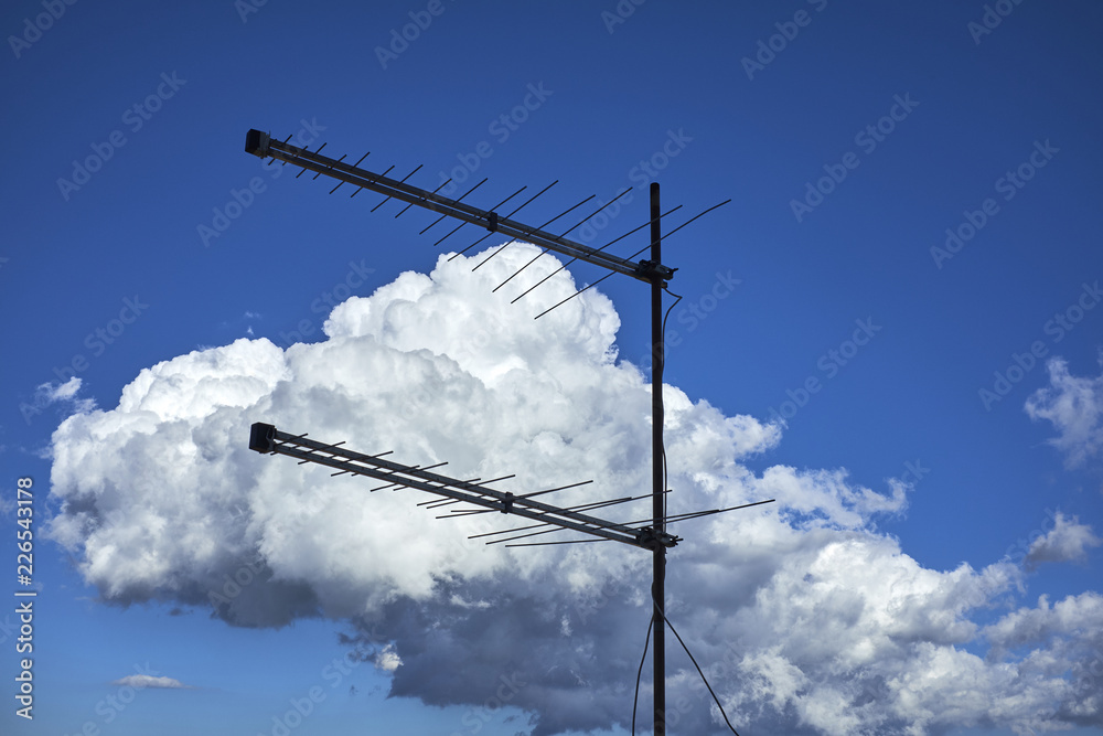 antenna televisiva di privata abitazione su un cielo azzurro con  nuvole