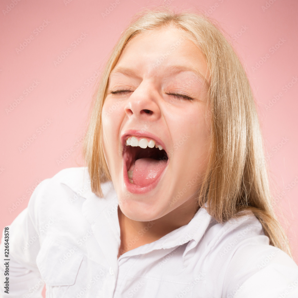 Do not miss. Young casual teen girl shouting. Shout. Crying emotional teenager screaming on pink studio background. Female half-length portrait. Human emotions, facial expression concept. Trendy Do not miss. Young casual teen girl shouting. Shout. Crying emotional teenager screaming on pink studio background. Female half-length portrait. Human emotions, facial expression concept. Trendy