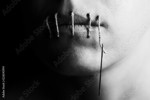 Artistic conceptual photo of a woman with stitches in lips
