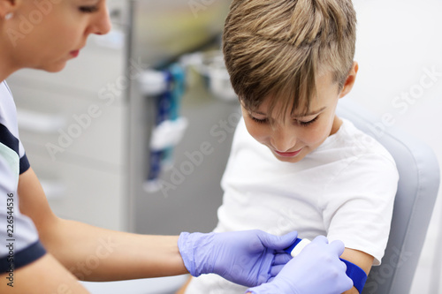 Cuadro en lienzo Brave little boy having blood collection for tests