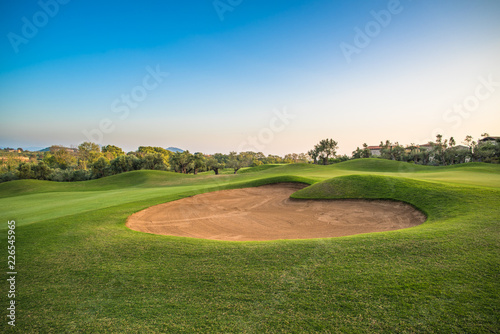 Heart shape sand bunker on the green golf course.