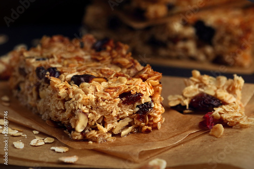 Homemade granola bars with nuts and cranberries over black background