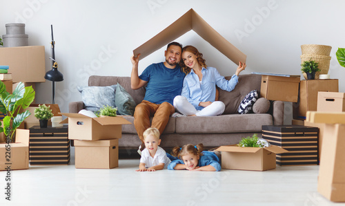 happy family mother father and children move to new apartment and unpack boxes photo