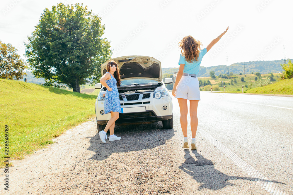 two women at roadside need help with broken car two women at roadside need help with broken car