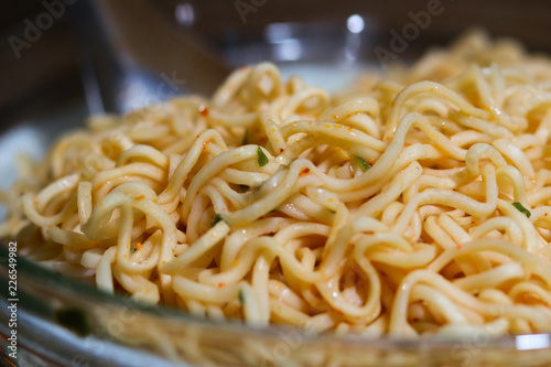 Instant noodles in bowl on wooden background.