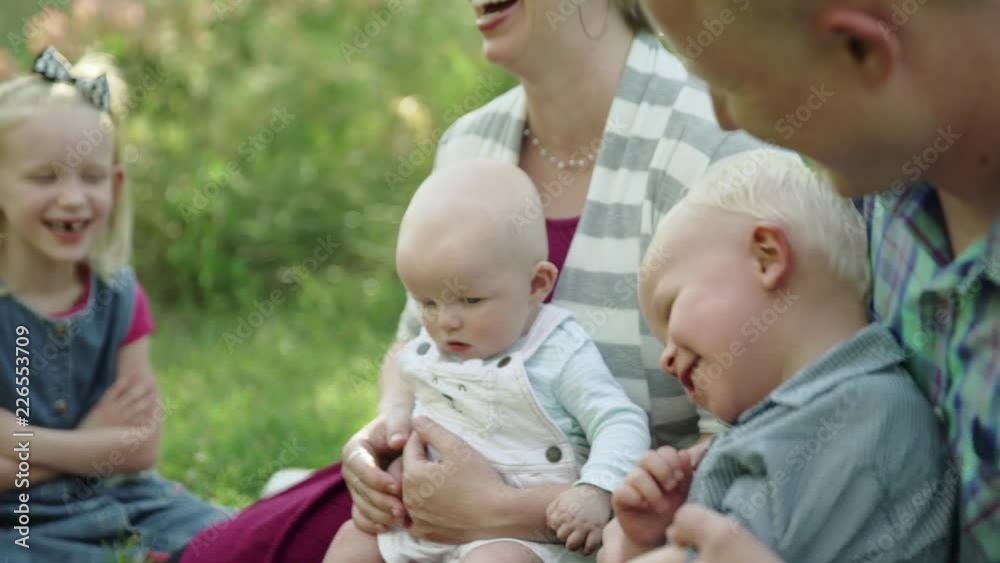 Happy family sitting on a grass during summer rest in park slow motion Full HD Happy family sitting on a grass during summer rest in park slow motion Full HD