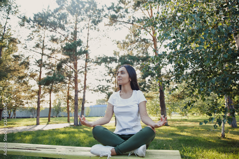 young girl meditating in the street, sitting on a bench young girl meditating in the street, sitting on a bench