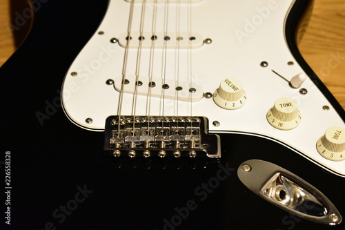 Obraz na płótnie Black and white electric guitar body closeup. Bridge, single coil pickups, pickguard, knobs and jack. w salonie