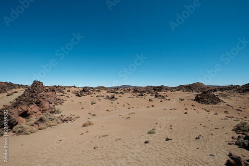 desert landscape with volcanic rocks and clear blue sky copy space -