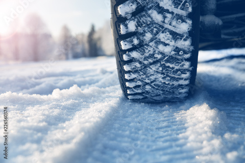 Closeup of car tires in winter on the road covered with snow © candy1812