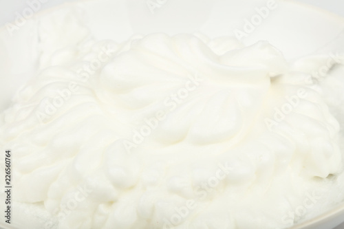 Close up fresh whipped cream in white bowl