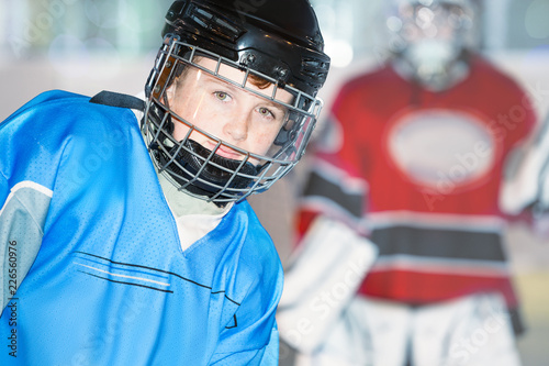 Junior hockey player in blue uniform and helmet