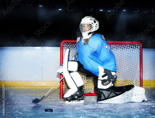 Girl goaltender protecting net during hockey match photo