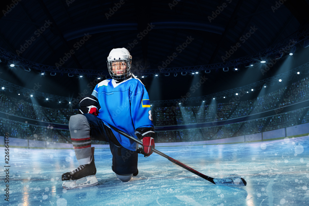 Fototapeta premium Hockey player with stick standing on one knee