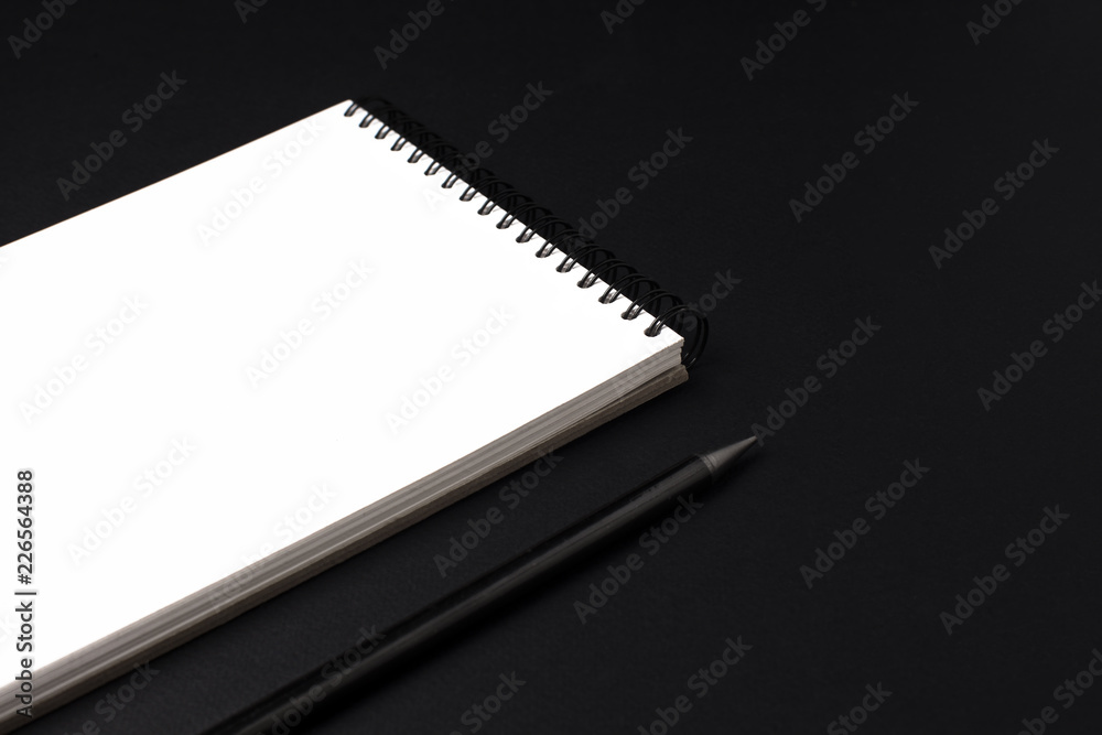 Opened clean notebook or sketchbook with pencil on black background Opened clean notebook or sketchbook with pencil on black background