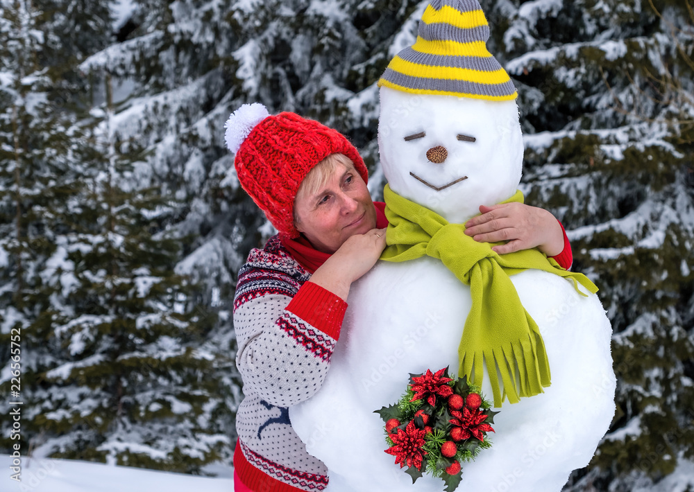 Woman hugging funny snowman.