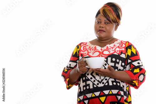 Studio shot of fat black African woman holding coffee cup