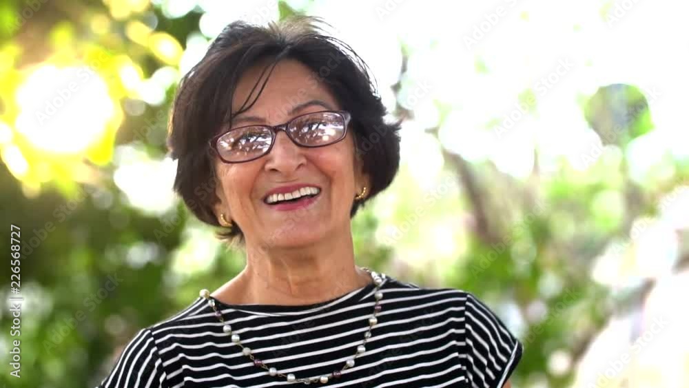 portrait of senior brazilian woman looking at camera in sunset and smiling. Horizontal shape, copy space. portrait of senior brazilian woman looking at camera in sunset and smiling. Horizontal shape, copy space.