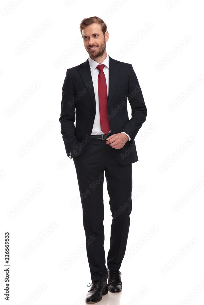 relaxed businessman walking and looking to side while smiling relaxed businessman walking and looking to side while smiling