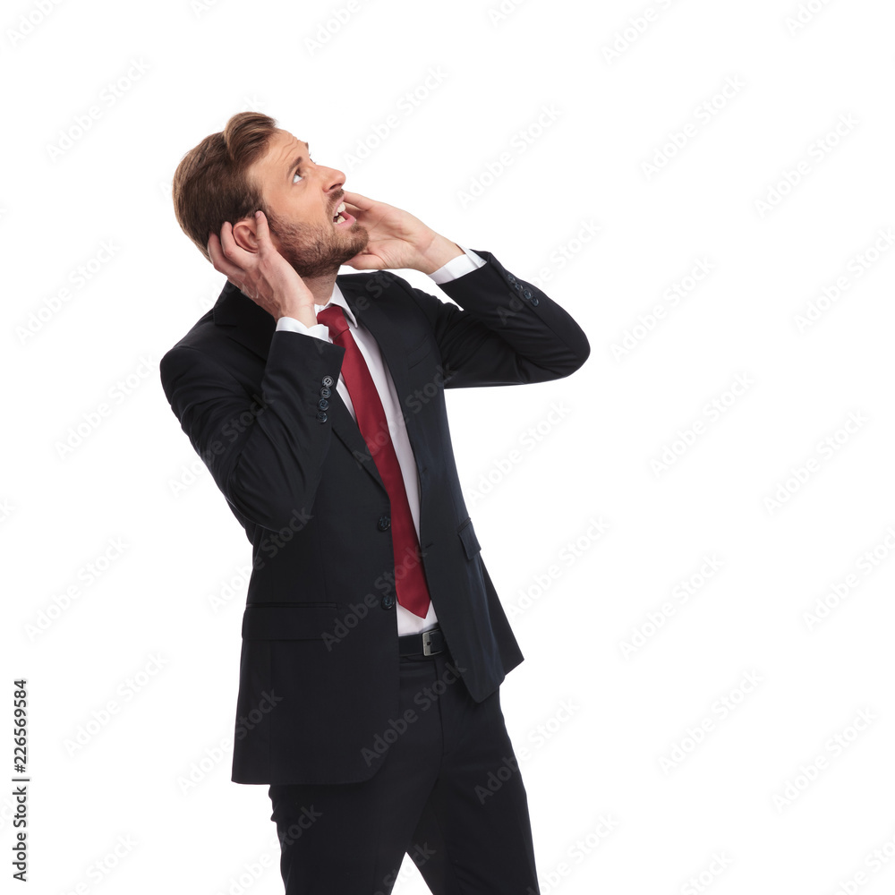 portrait of frightened businessman looking up to side portrait of frightened businessman looking up to side