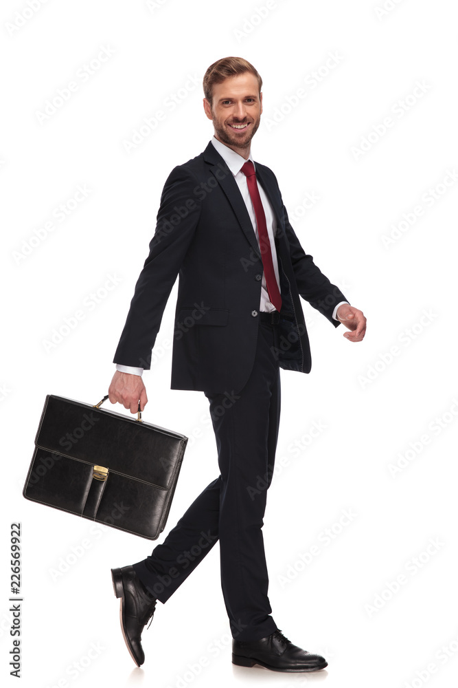 side view of cheerful businessman swinging his suitcase and walking side view of cheerful businessman swinging his suitcase and walking