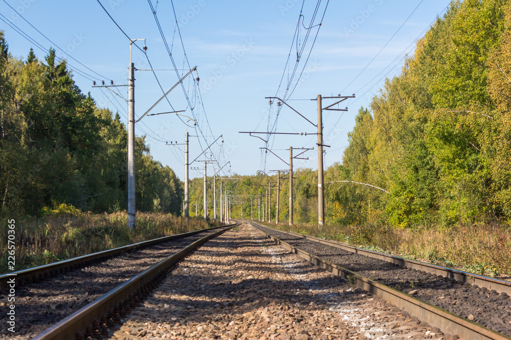 Double-track electrified railway on a sunny autumn day Double-track electrified railway on a sunny autumn day