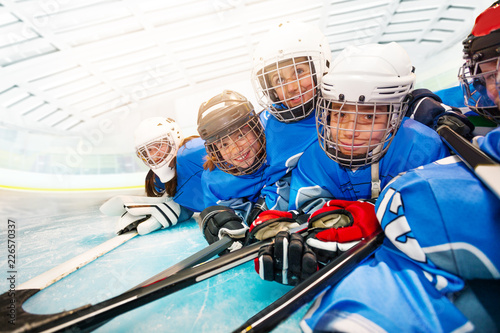 Joyful kids in hockey uniform laying on ice rink photo