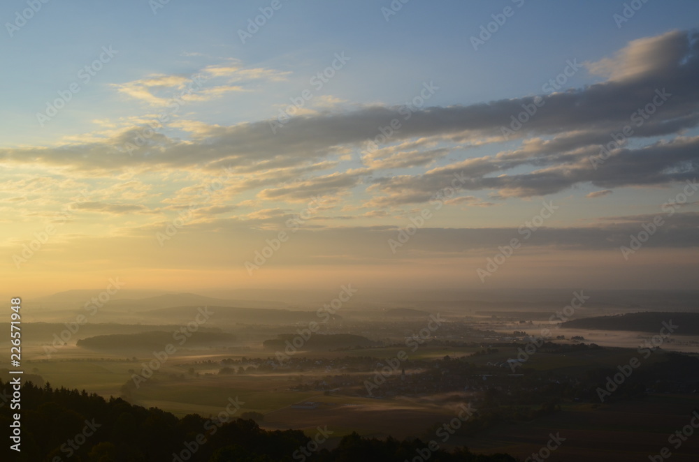 Blick von einem Berg, kurz nach Sonnenaufgang, mit Bodennebel