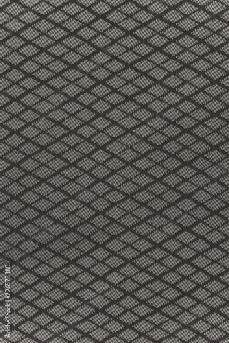 Highly detailed all over background texture of black and gray diamond-shaped stripes textile in synthetic fabric.