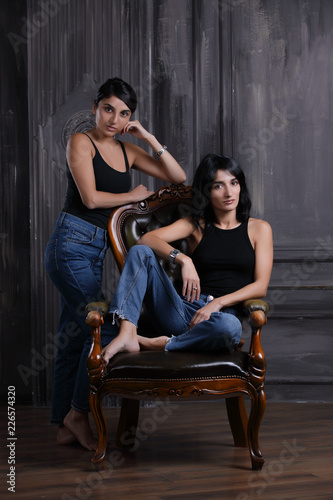 Studio portrait of two sisters on chair