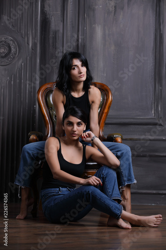 Studio portrait of two sisters on chair © antgor