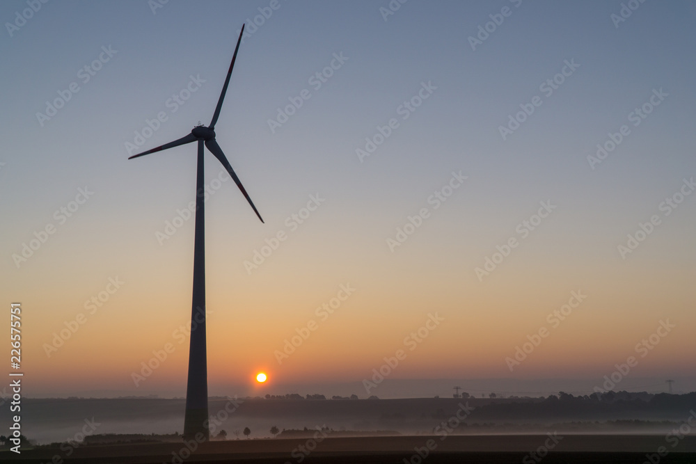 Wind turbines in the morning, partially covered by mist Wind turbines in the morning, partially covered by mist