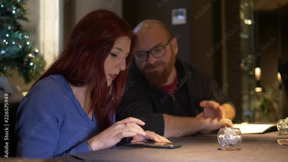 lovers at restaurant talking and using smartphone lovers at restaurant talking and using smartphone