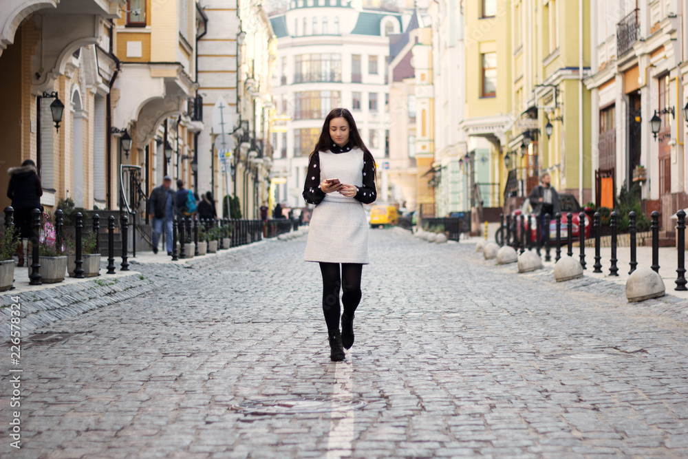 fashion happy woman walking smart phone on city street