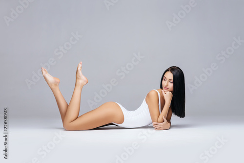 Fototapeta Naklejka Na Ścianę i Meble -  Fit and sporty girl in white swimsuit. Sport, fitness, diet, weight loss and healthcare concept.