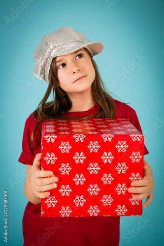 Christmas Girl Thinking about Her Gift, Isolated on Teal © IdeaBug, Inc.