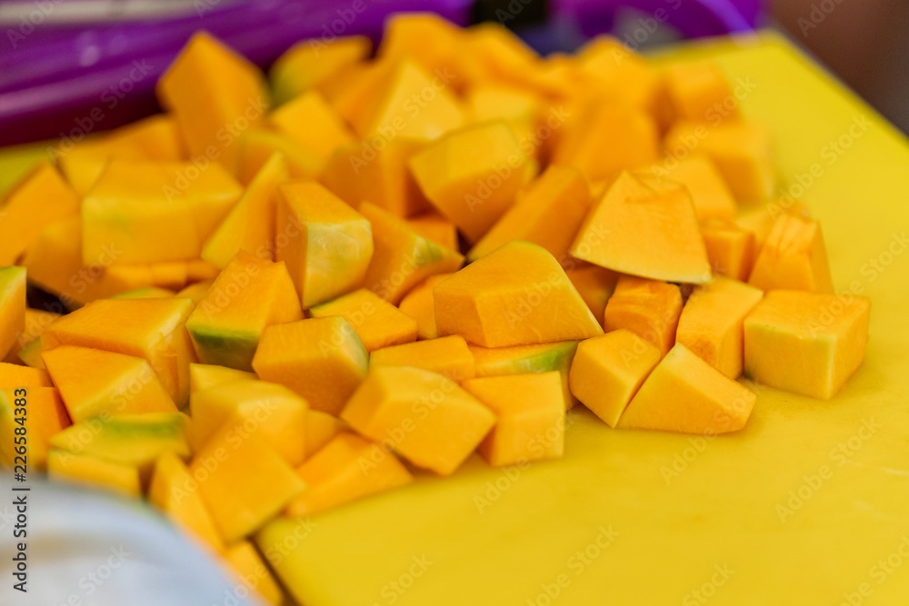 Cutted Pumpkin Pieces on the Yellow Plastic Board Cutted Pumpkin Pieces on the Yellow Plastic Board