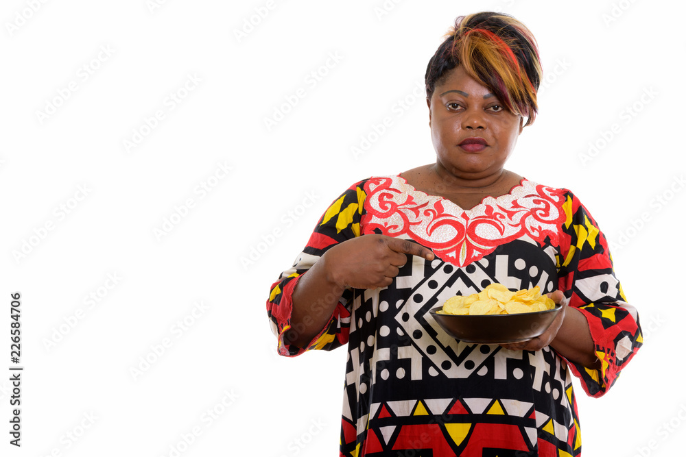 Studio shot of fat black African woman holding and pointing at b Studio shot of fat black African woman holding and pointing at b