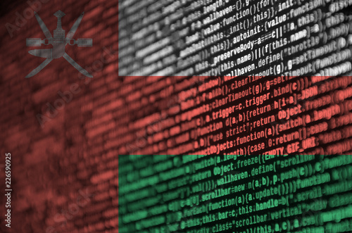 Oman flag  is depicted on the screen with the program code. The concept of modern technology and site development photo