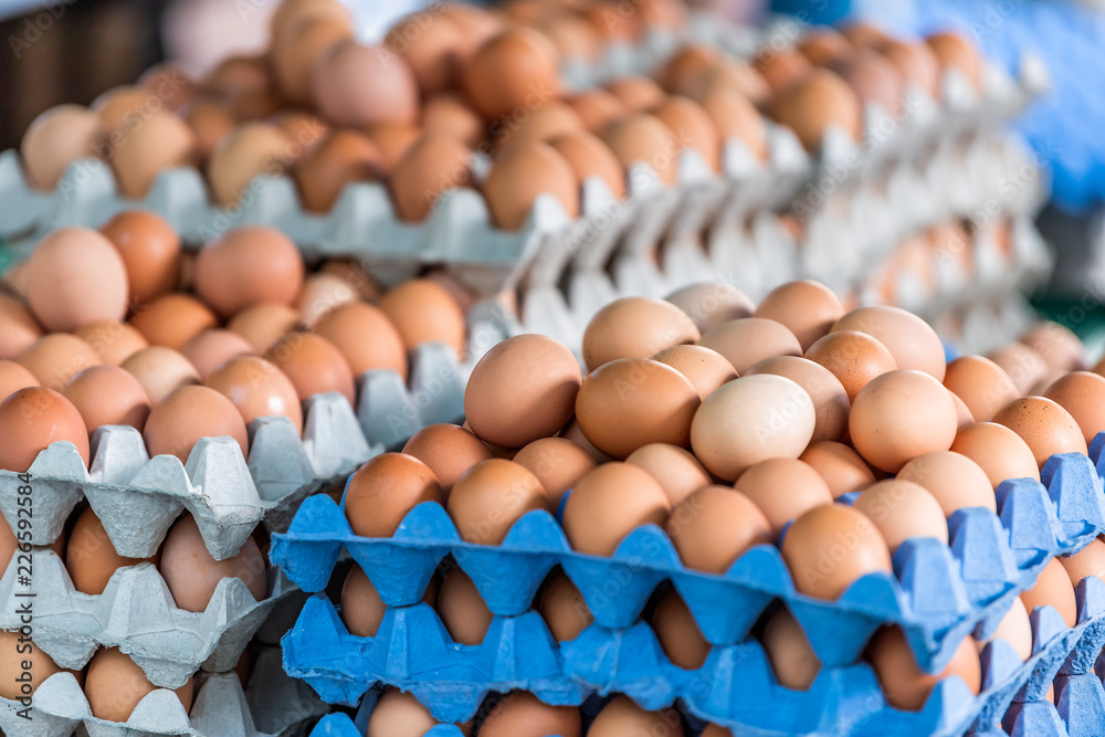 Closeup of many trays of farm fresh brown and white multicolored eggs on display in farmer's market in London, UK Closeup of many trays of farm fresh brown and white multicolored eggs on display in farmer's market in London, UK