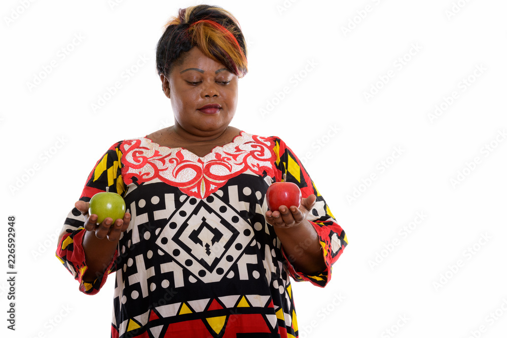Studio shot of fat black African woman holding green apple and l Studio shot of fat black African woman holding green apple and l