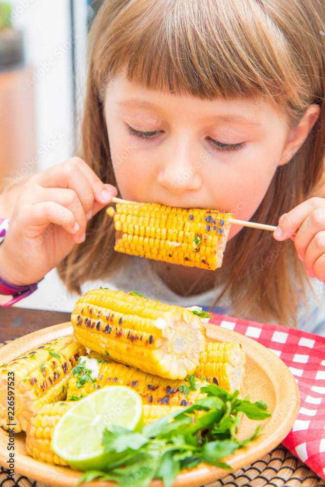 child eating delicious grilled corn child eating delicious grilled corn