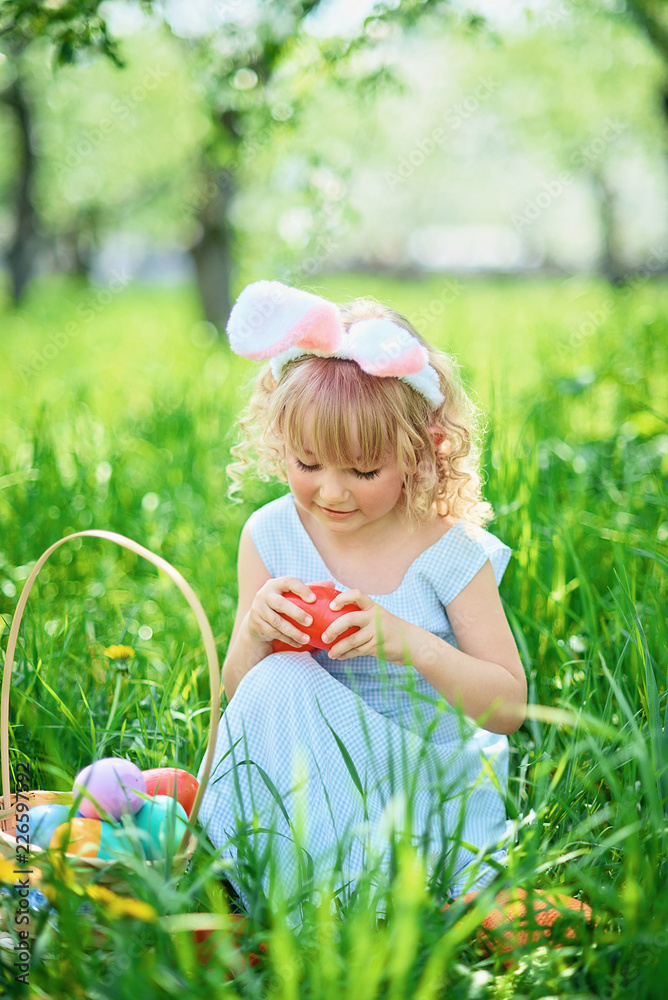 Cute funny girl with Easter eggs and bunny ears at garden. easter concept. Laughing child at Easter egg hunt Cute funny girl with Easter eggs and bunny ears at garden. easter concept. Laughing child at Easter egg hunt