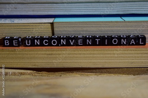 Be unconventional on wooden blocks. Motivation and inspiration concept. Cross processed image