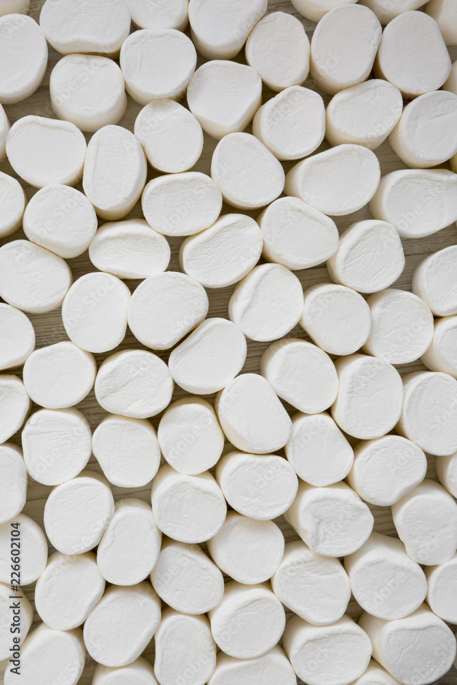 Closeup of sweet white marshmallows over white wooden background. Top view, overhead. Closeup of sweet white marshmallows over white wooden background. Top view, overhead.