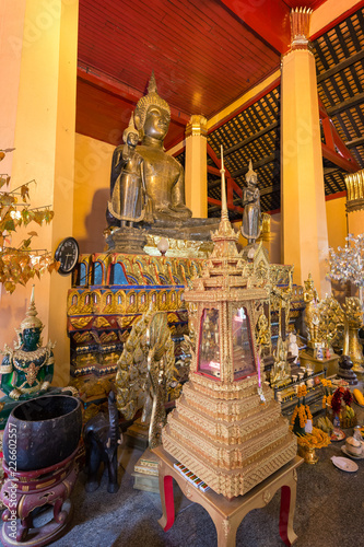 Altar with many golden Buddha statues and other items at the Wat Ong Teu Mahawihan (Temple of the Heavy Buddha), a Buddhist monastery, in Vientiane, Laos. photo