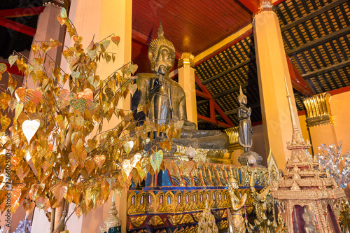 Altar with several golden Buddha statues and other items at the Wat Ong Teu Mahawihan (Temple of the Heavy Buddha), a Buddhist monastery, in Vientiane, Laos.