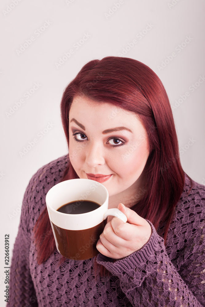 Close up young lady holding cup of coffee close to her face Close up young lady holding cup of coffee close to her face